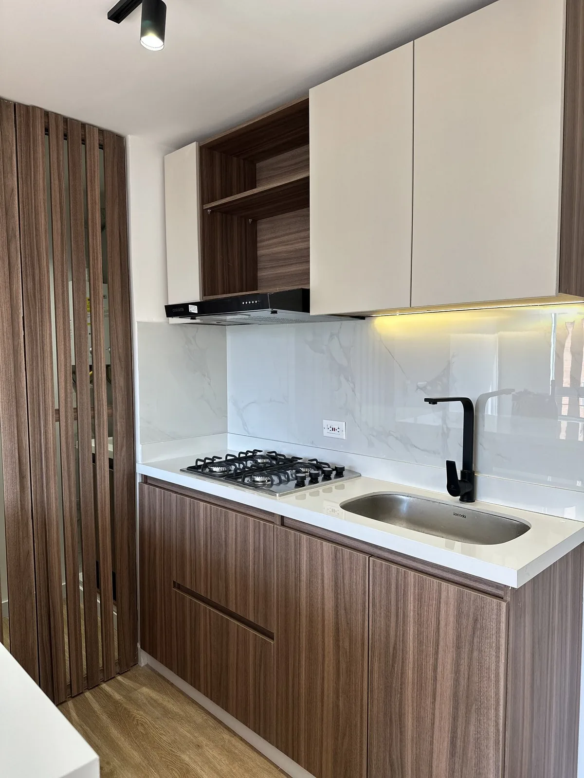 Cocina con luz bajo los muebles superiores